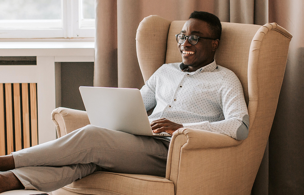 Kvass lanserer integrasjon mot Bolignett, mann som sitter i en stol med laptop på fanget